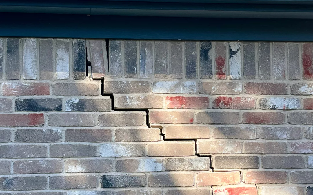 signs to look for when a foundation needs repair. A home with exterior cracks on it's brick wall.